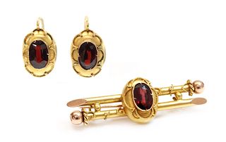 A Russian gold garnet set brooch and earrings suite,