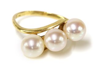 A three stone cultured pearl crossover ring, by Mikimoto,