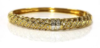 An 18ct gold diamond set oval hinged bangle,