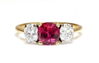 An 18ct gold three stone fracture filled ruby and diamond ring, by Kutchinsky,