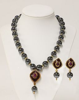 An 18ct gold haematite, ruby and enamel necklace and earrings suite, by Amr Shaker, Geneve, c.1990,