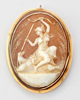 A SHELL CAMEO BROOCH, depicting Diana seated with a bow and arrow and a hou