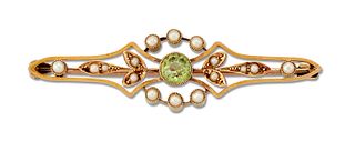 A LATE VICTORIAN PERIDOT AND SEED PEARL BROOCH, a round-cut peridot within 