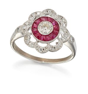 A RUBY AND DIAMOND CLUSTER RING, a round brilliant-cut diamond within a mil