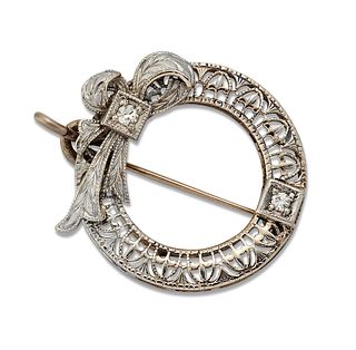A DIAMOND BROOCH / PENDANT, of pierced circular form tied by a ribbon and s