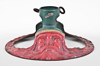 An unusual early 20th century cast iron Christmas tree stand with Santa masks
