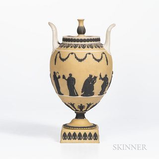 Wedgwood Yellow Jasper Dip Vase and Cover, England, c. 1930, urn finial with applied white upturned loop handles, black floral festoons over Muses and