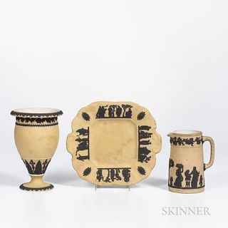 Three Wedgwood Yellow Jasper Dip Items, England, c. 1930, each with applied black jasper relief, two with classical figures, a cake tray, lg. 10 3/8; 