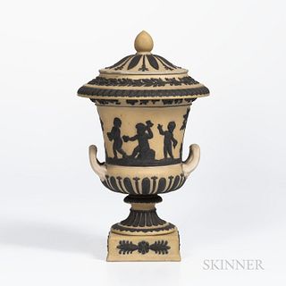 Wedgwood Yellow Jasper Dip Campana Vase and Cover, England, c. 1930, applied black jasper classical figures in relief below a fruiting grapevine band,