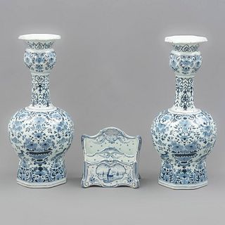 Guarnición. Países Bajos, SXX. Elaborados en porcelana Royal Bonn Delft. Consta de: 2 floreros laterales y portacartas. Piezas: 3