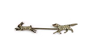 A Continental silver paste set hunting scene pin,