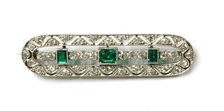An early 20th century white gold emerald and diamond brooch,