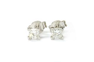 A pair of white gold princess cut diamond stud earrings,