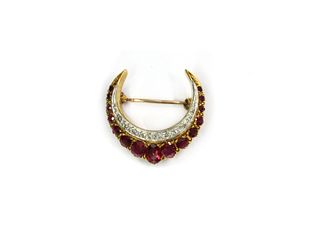 A gold ruby and diamond crescent brooch,