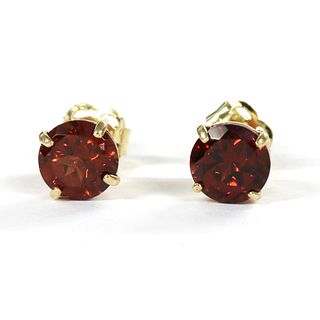 A pair of gold single stone garnet stud earrings,