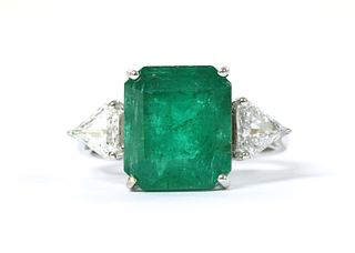 A white gold three stone emerald and diamond ring,