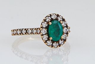 Lady's 14K Rose Gold Dinner Ring, with a .77 carat oval emerald, atop a scalloped, border, the scalloped shoulders of the band, also mounted with roun