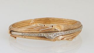 Lady's 14K Yellow and White Gold Hinged Bangle Bracelet, c. 1950, of graduated width, with a central white gold band mounted with small round diamonds