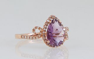 Lady's 14K Rose Gold Dinner Ring, with a pear shaped 1.63 ct. amethyst, atop a conforming border of tiny round diamonds, the swirled shoulders of the 