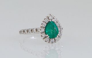 Lady's 14K White Gold, Dinner Ring, with a pear shaped .8 carat emerald, atop a conforming border of round diamonds, the shoulders of the band also mo