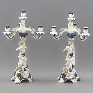 Par de candelabros. México, SXX. Elaborados en porcelana de Cuernavaca. Para 4 luces. Brazos orgánicos decorados con amorcillos.