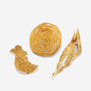 A collection of three eighteen karat gold brooches