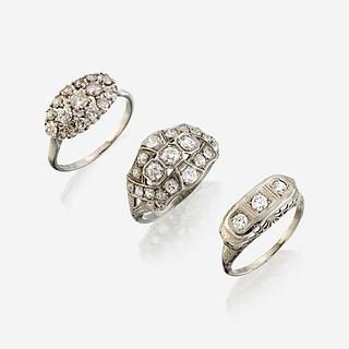 A collection of three white metal and diamond rings