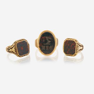 A collection of three gold and bloodstone men's rings