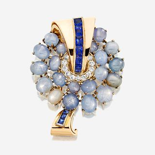 A sapphire, white stone, and gold brooch