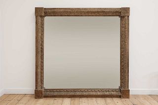 A monumental carved pine-framed wall mirror,