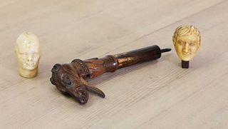 A carved wooden walking stick or parasol handle,