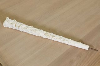 An ornately carved ivory parasol handle,