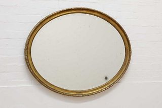 A gilt-framed oval mirror,