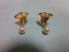 A pair of pearl and diamond earstuds, each with a pierced triangular fan motif set with three round