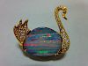 An opal and diamond brooch in the form of a swan, the body of the swimming bird formed by an ovoid f