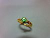 An 18ct gold ring set with a green garnet and diamond highlights, the bright apple green round cut g