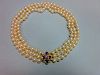 A three row pearl necklace with gold, amethyst and seed pearl clasp, the uniform 7.5-8mm cultured pe