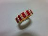 A contemporary 18ct gold ruby and diamond band ring, set all around the front with alternating verti