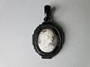 A Victorian carved jet mounted shell cameo pendant, the white on grey cameo depicting a Bacchante in
