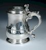 A George II silver tankard, by Lewis Hamon, London 1737, of plain baluster form with moulded edge an