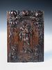 An 18th century North European relief carved oak panel, depicting the Madonna and Child within an ar