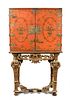 An 18th century Chinese red lacquer cabinet on a giltwood stand, decorated with a traditional river