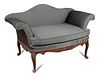 A small George III style mahogany sofa, with camel back and outscrolling arms, carved show wood, uph
