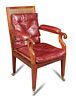 A Regency mahogany library bergere, the arms upholstered in red leather, cane seat with loose cushio