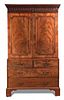 A George III mahogany linen press, with dentil and corbel moulded frieze, panelled doors enclosing s