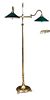 A brass two branch floor standing reading light, the branches with green glass shades 168cm (66in) <