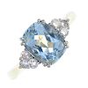An 18ct gold aquamarine and diamond dress ring. The cushion-shape aquamarine, with brilliant-cut dia