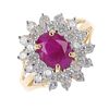An 18ct gold ruby and diamond cluster ring. The oval-shape ruby, within a brilliant-cut diamond doub