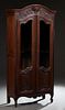 French Louis XV Style Carved Oak Bookcase, 20th c., the arched crown over a floral basket carved frieze above double doors with arched glazed upper pa