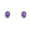 A pair of amethyst and diamond cluster ear studs. Each designed as an oval-shape amethyst, within a